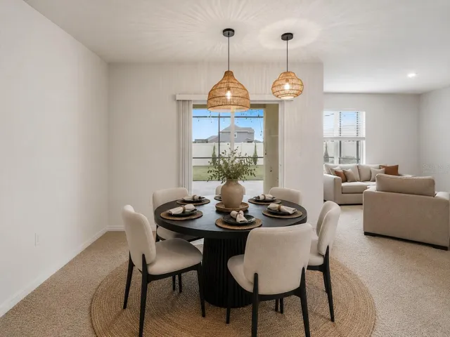 Virtually staged, Bright, spacious dining room featuring seamless sliding glass door access to the private, screened-in patio, perfect for indoor-outdoor entertaining.
