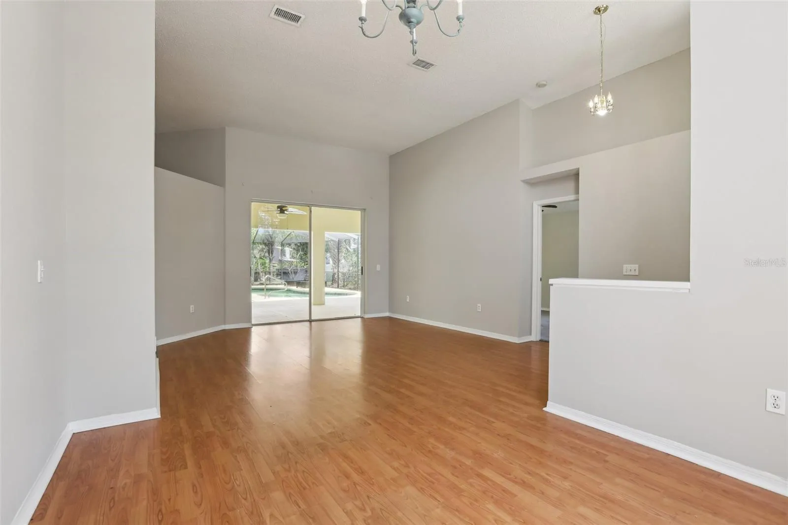 Large Living room overlooks the lanai and pool area