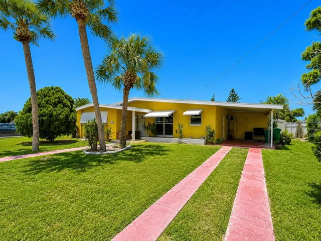 Charming Front Exterior with Covered Entry, Carport, Mature Palm Trees and Attractive Curb Appeal