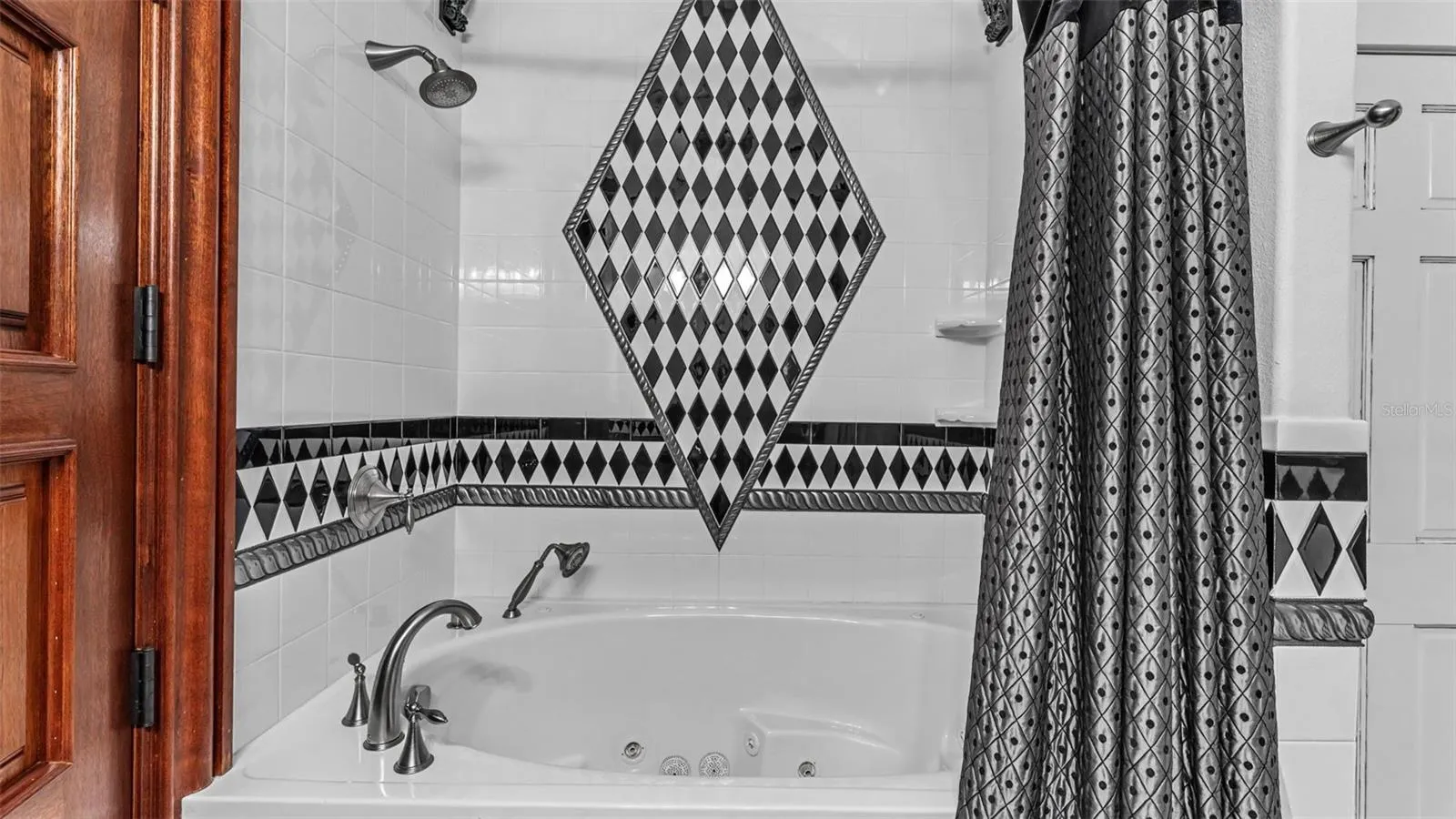 Guest Bath Jacuzzi / Full Shower  located downstairs in the En- Suite Guest Bedroom #4. The Linen closet is conveniently located inside the Bathroom.