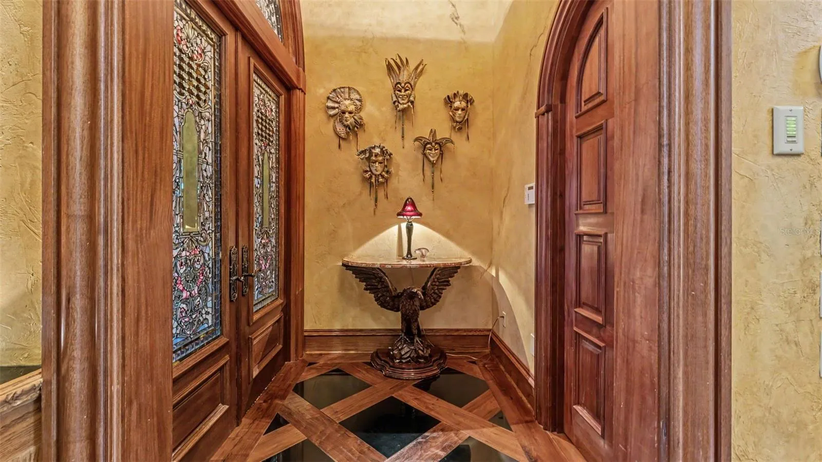 Grand Entrance to the Primary suite to the left through the stain Glass double doors. Walk in Storage/ Supply closet to the right.
