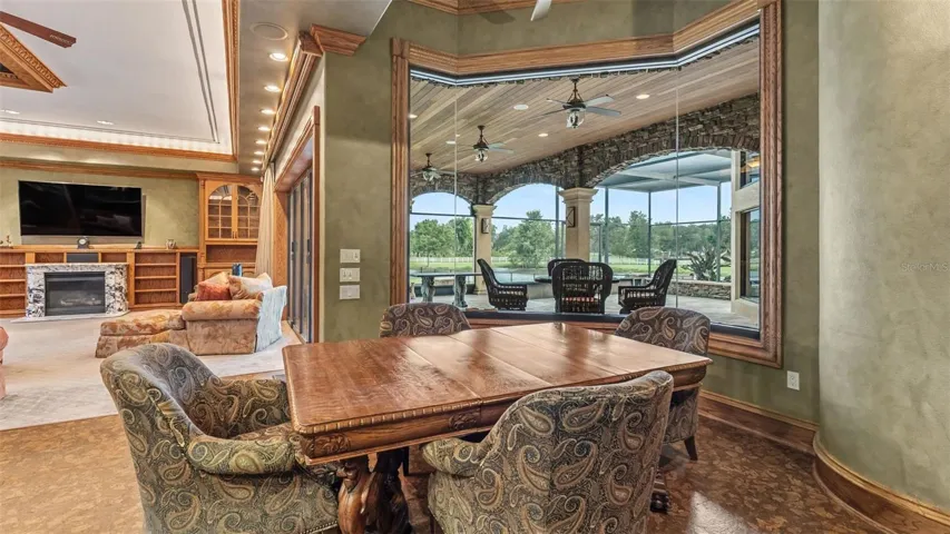 Eat In dining situated at this Frameless glass window  overlooking the Covered Lanai & Pond views.  Antique furniture conveys.