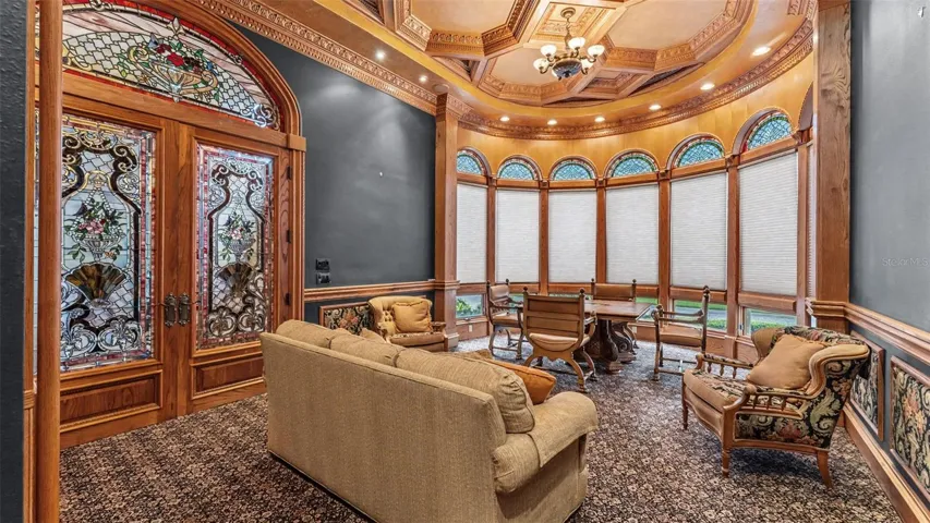 Arched stain glass windows are beautifully displayed  in the Boardroom/ Library.  Other appointments include a coffered ceiling, Built in storage, and  beautiful furnishings