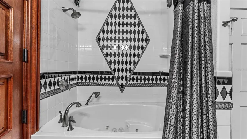 Guest Bath Jacuzzi / Full Shower  located downstairs in the En- Suite Guest Bedroom #4. The Linen closet is conveniently located inside the Bathroom.