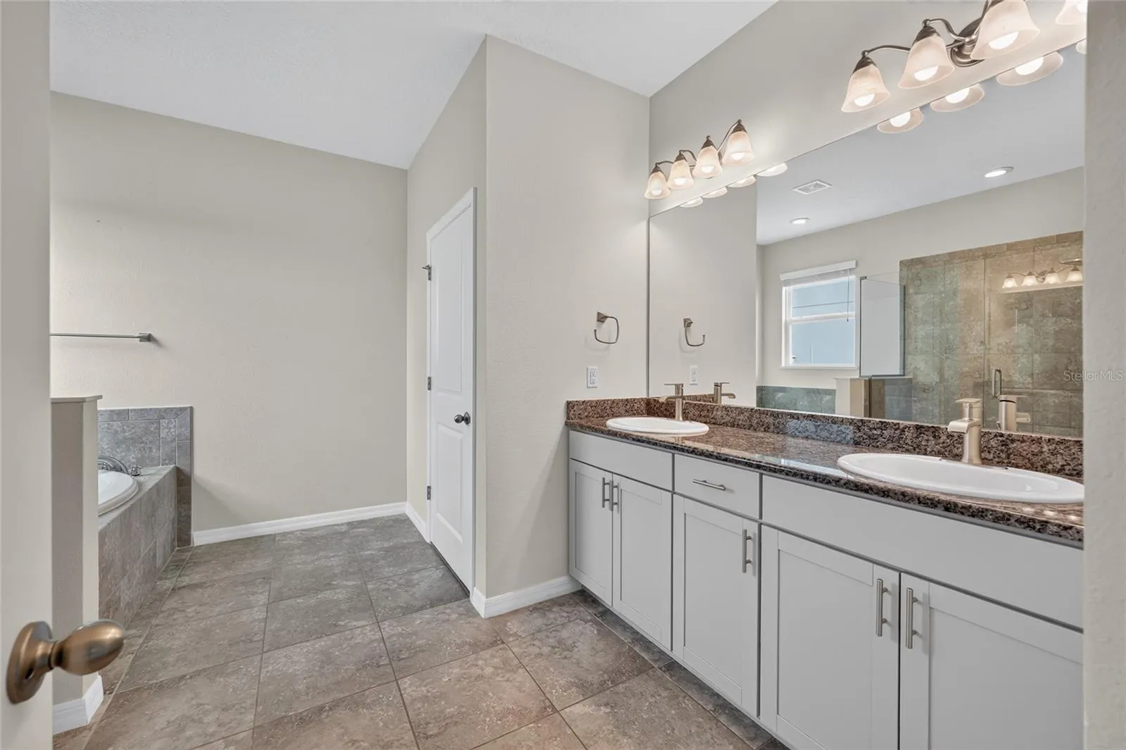 Primary bathroom with dual sinks and high vanity