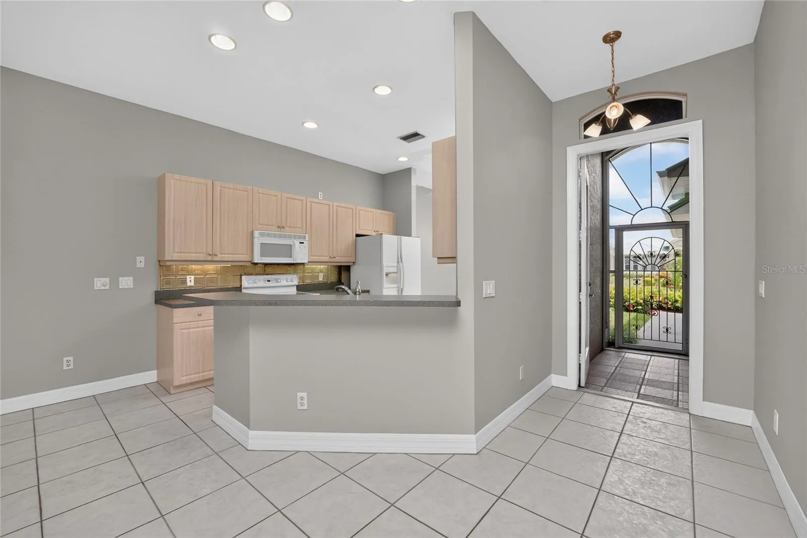 View of the kitchen, foyer and tiled front entry from the great  room.