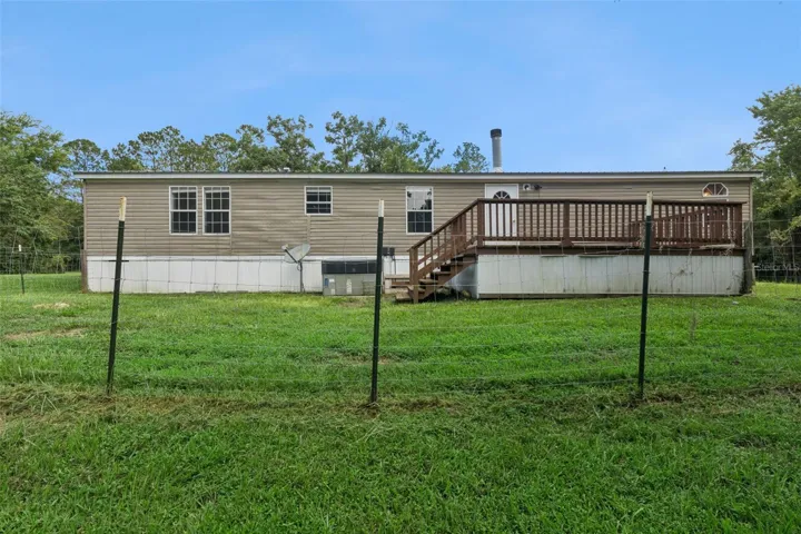 Rear view of house and fenced part of yard