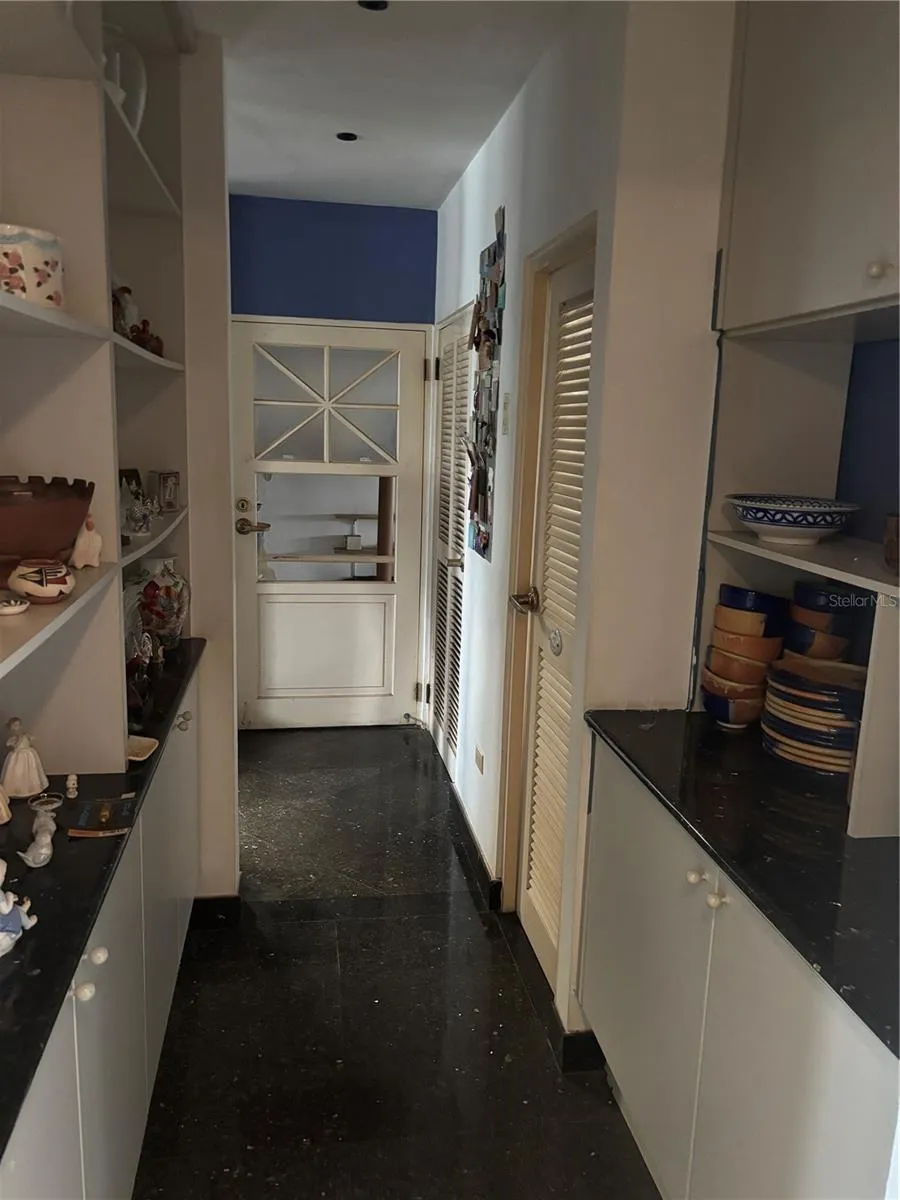 Hallway Pantry with half bath on the right, laundry room beyond and garage door at the end.