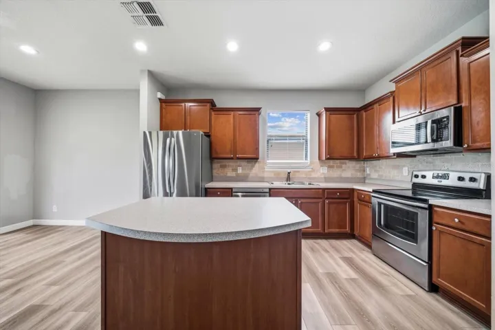 Center Island, stainless appliances, neutral backsplash