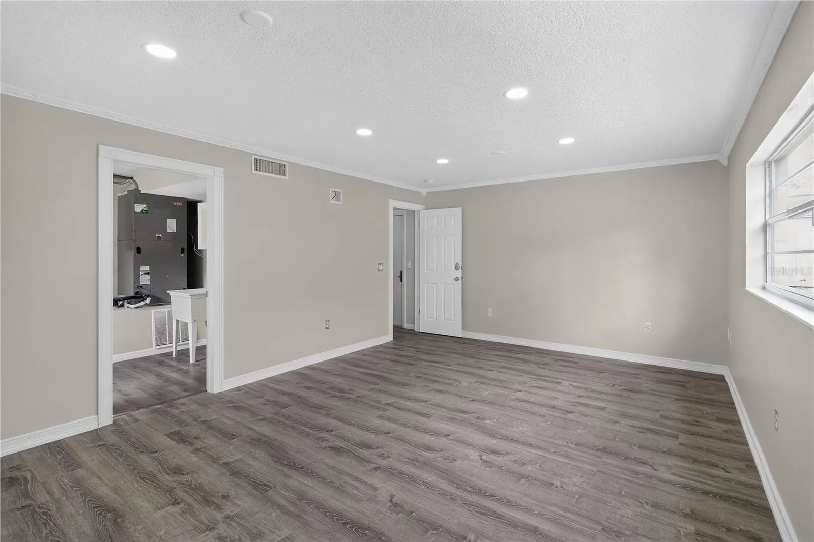 View 2 - Bedroom #5, en Oversized ground floor bedroom offers flexible use — ideal as a guest suite, craft studio, home office, fitness room.  This multi purpose space has GREAT VALUE and not just “another bedroom.”