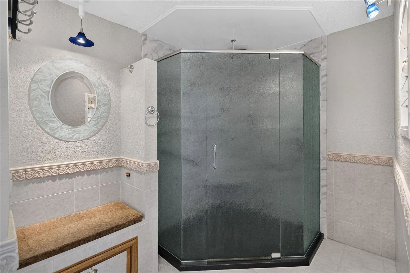 Walk-in shower for ease of access  (ceiling-mounted rain shower head).  A built in ledge outside the shower offers a convenient spot for towels, toiletries, or items for easy reach.