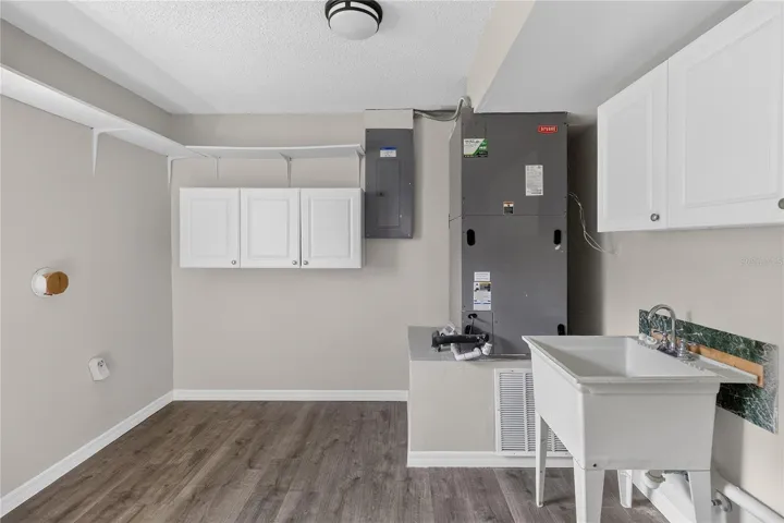 HUGE laundry room with shelving and utility sink.