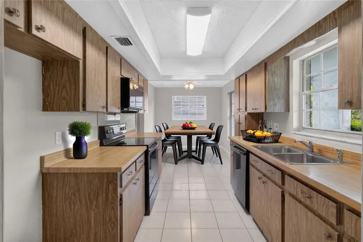 Kitchen is light and bright - having three (3) windows with a window over the kitchen sink.   A front-facing kitchen sink window brings in natural light and lets us keep an eye on what’s happening in the front of our home — deliveries, guests arriving, kids playing. (Virtual stage table / accessories)
