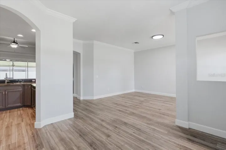 Formal living & dining area w/ arch entryway into kitchen & great rm