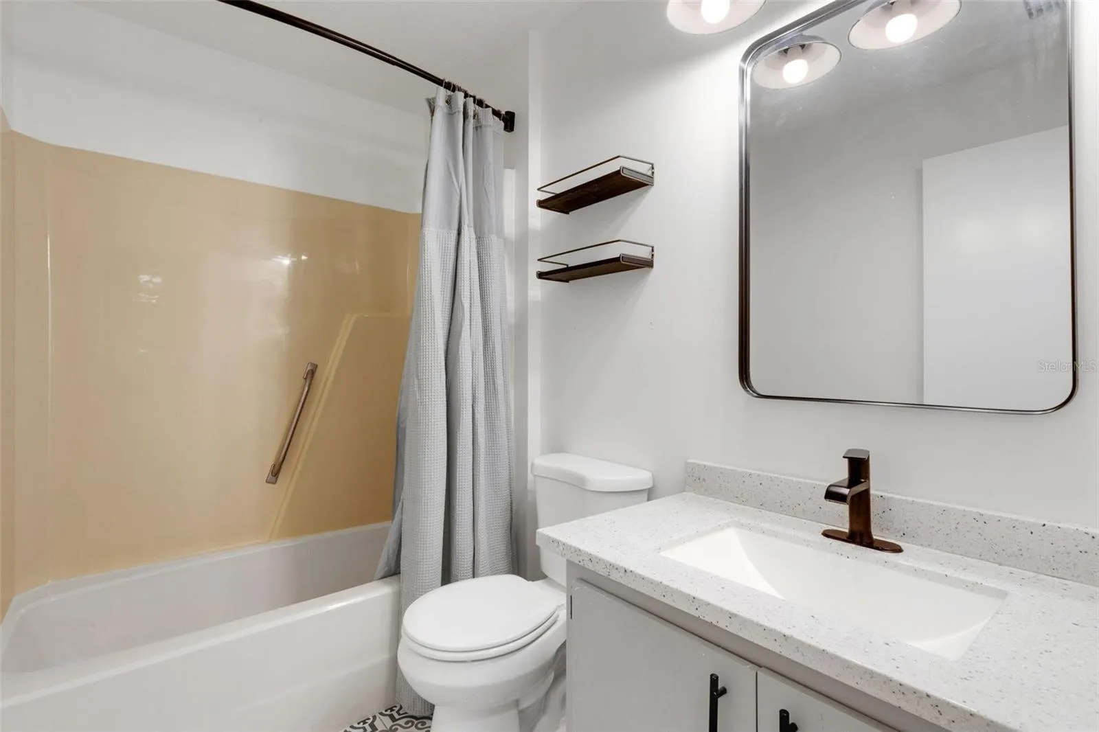 Guest bathroom featuring new vanity, plumbing fixture, mirror, lighting, tile et floor etc.
