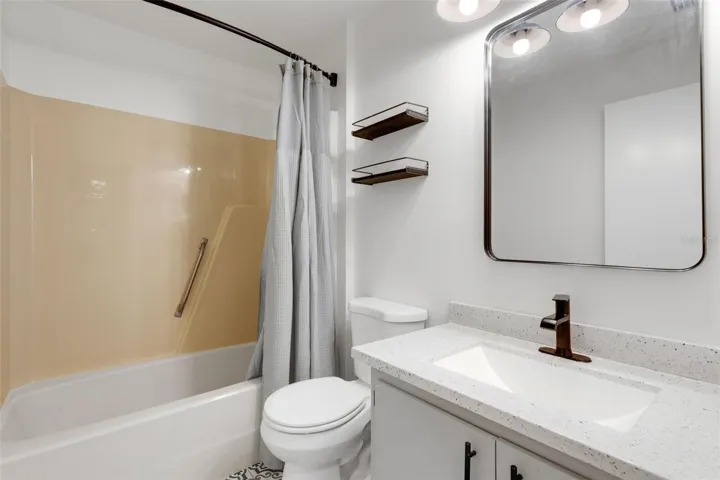 Guest bathroom featuring new vanity, plumbing fixture, mirror, lighting, tile et floor etc.