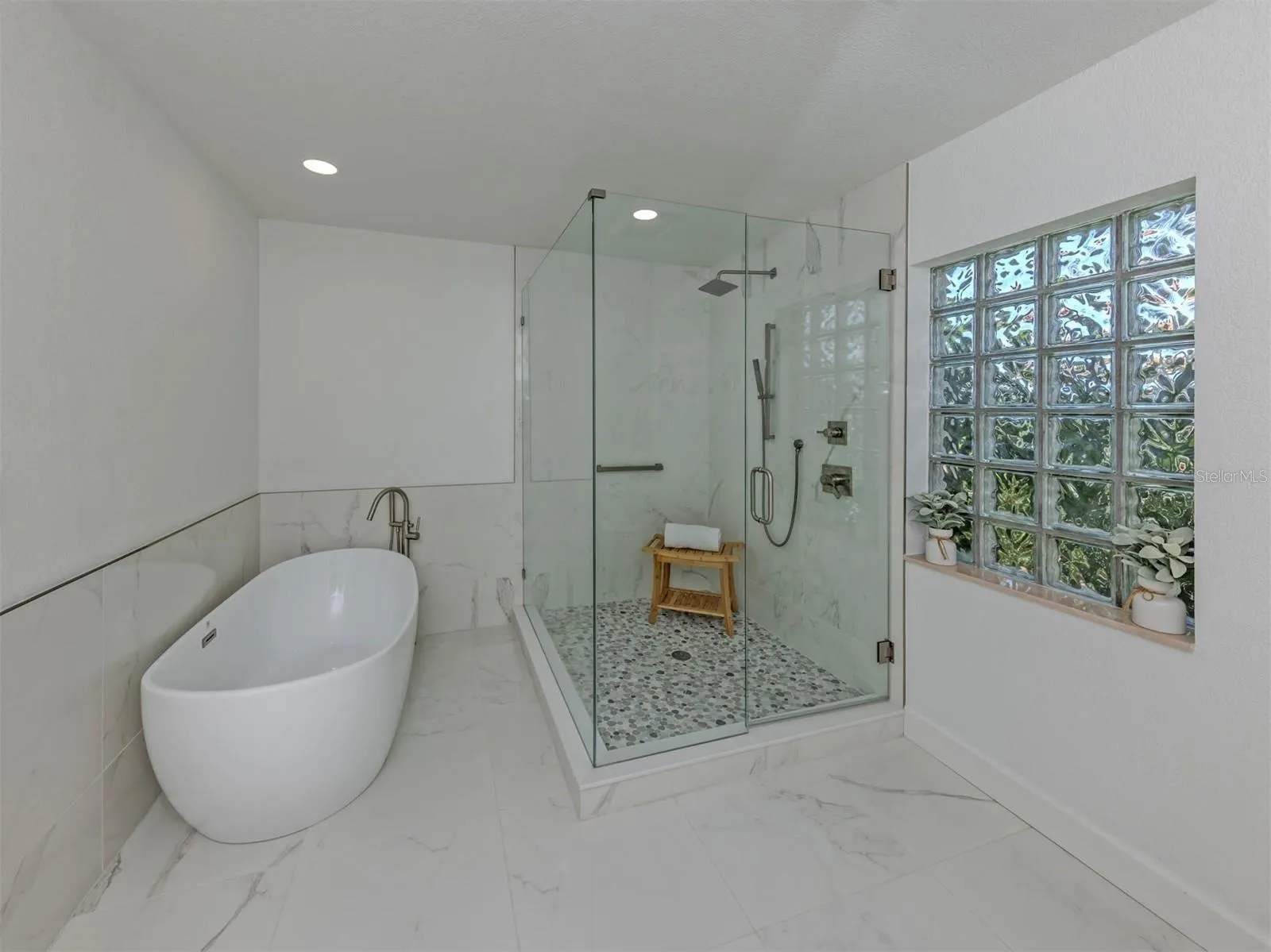 Enjoy the large soaking tub or glass enclosed shower in the primary bath