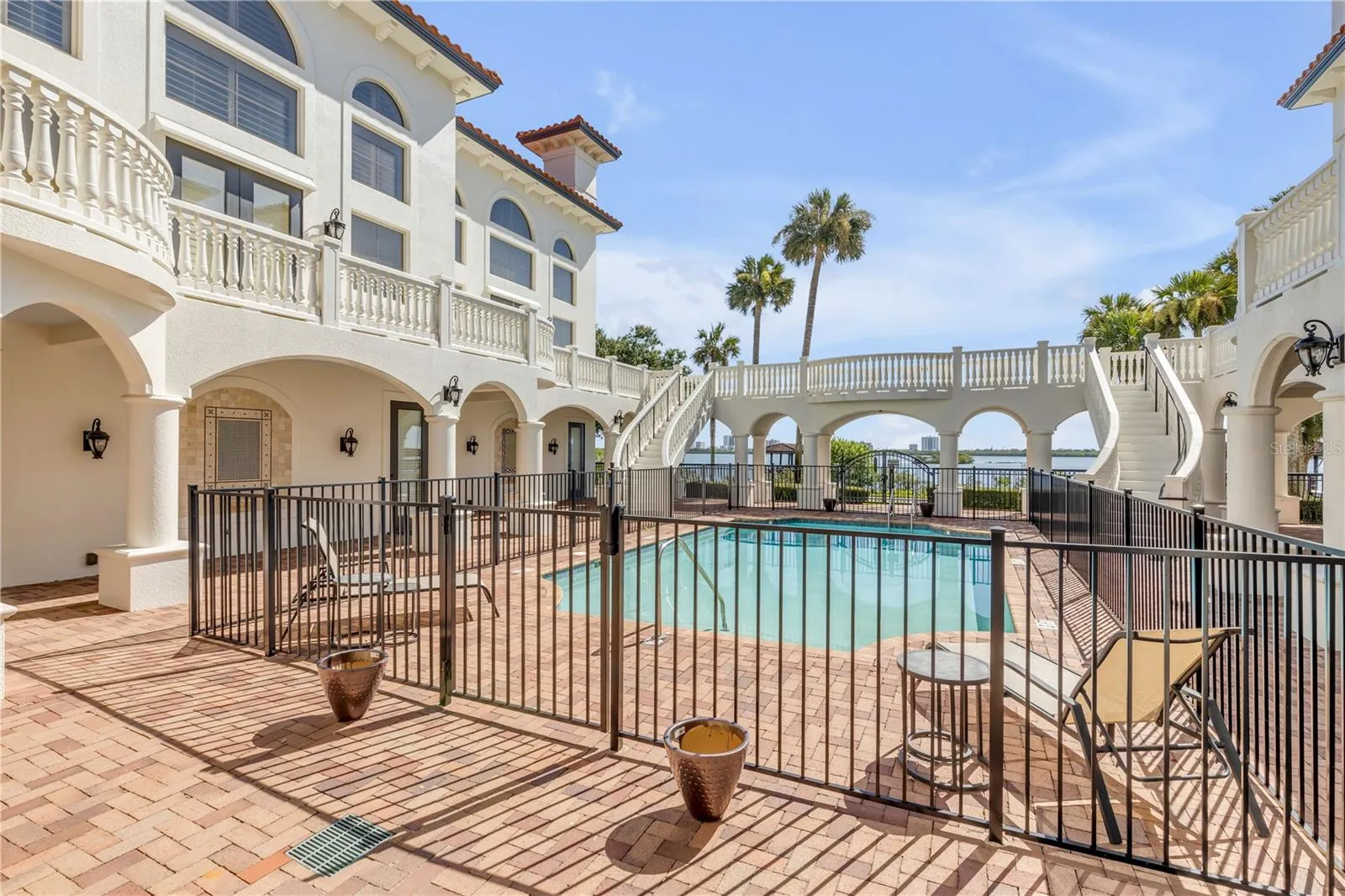 Common Balcony with dual curved staircases coming toward the pool area.