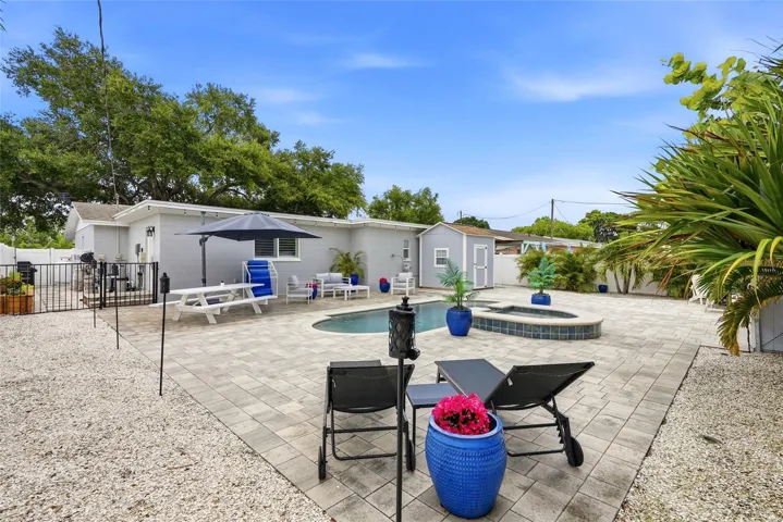 Your very own Maintenance FREE TROPICAL OASIS with a NEW Salt water pool & heated Spill over Spa; 3 Custom built Storage Sheds (2 with electrical); Fire pit; Vinyl privacy fence; and gorgeous brick pavers surrounded by Tropical landscaping