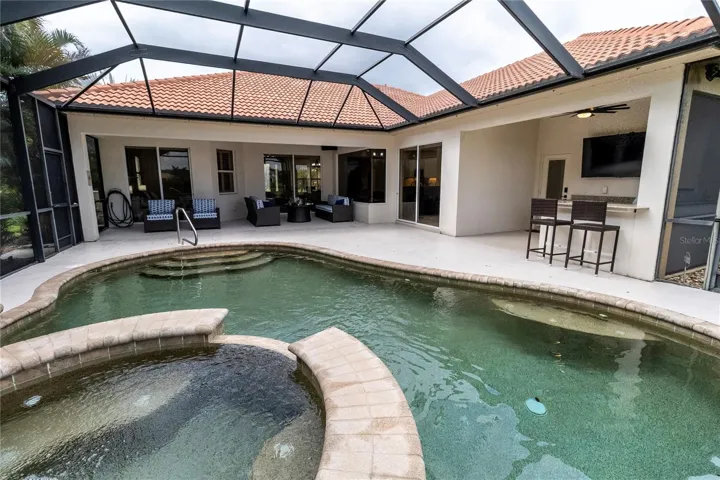 Resort-Style Pool &amp; Spa with an Expansive Pool Deck, Outdoor Kitchen &amp; Bar