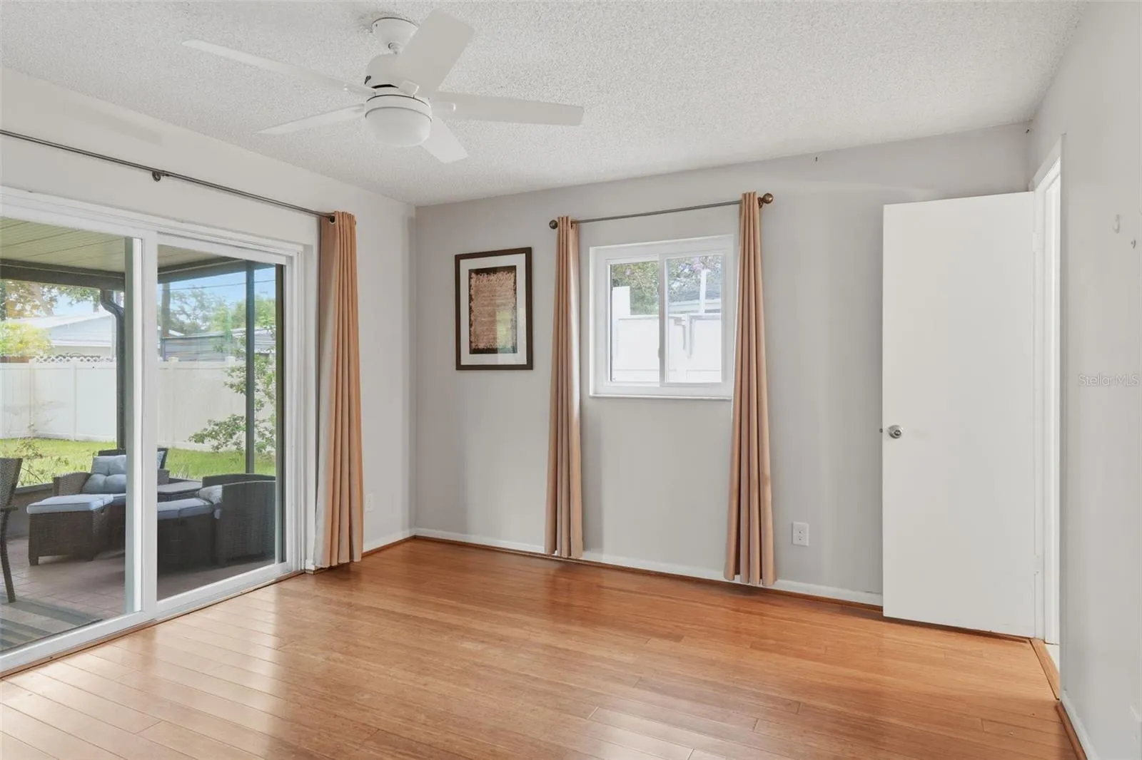 Primary Bedroom with entry to screened in back porch and yard