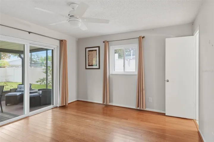 Primary Bedroom with entry to screened in back porch and yard