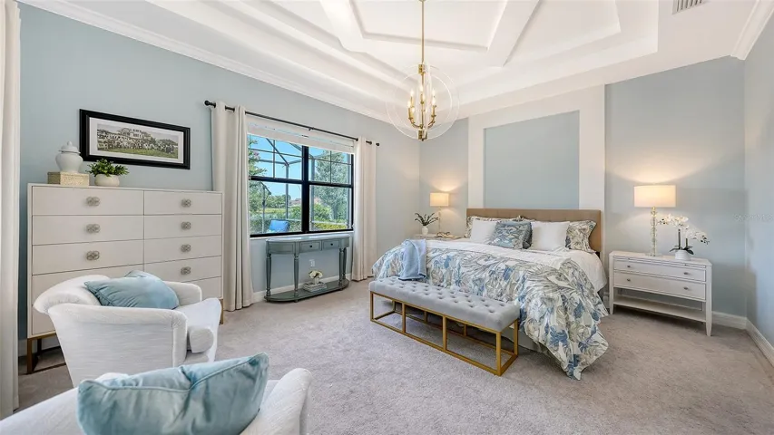 Primary suite has sitting area and detailed coffered ceiling