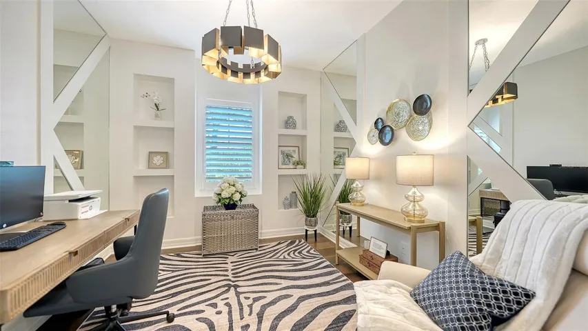 Private office with built-in shelves and mirrored accent walls