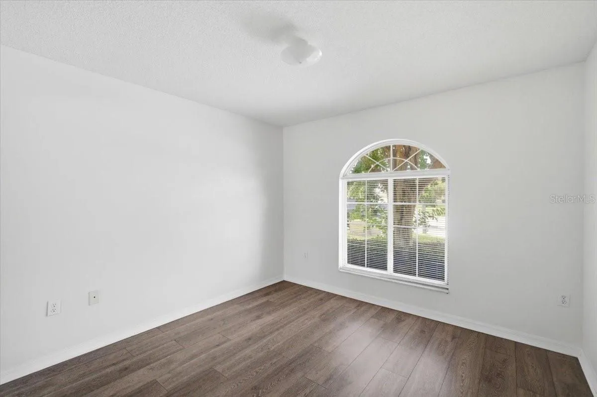 Spacious first bedroom, versatile layout ideal for use as a home office or guest suite.