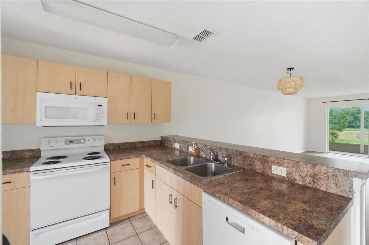 Cozy kitchen featuring all appliances and ample counter space, perfectly designed with an open-concept layout that overlooks the spacious living room.