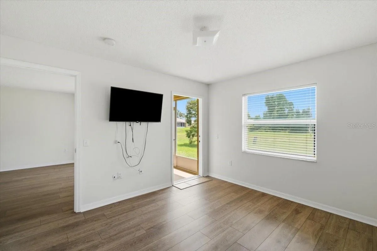 Primary bedroomPrimary bedroom featuring a spacious layout, an attached ensuite bathroom, and seamless, direct access to the enclosed rear porch for added convenience and private outdoor enjoyment.