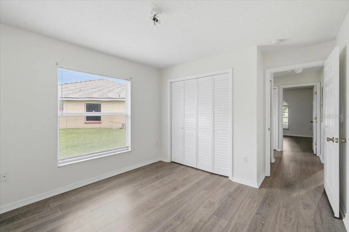 Second spacious bedroom with ample natural light, comfortably accommodating a queen-sized bed and additional furniture.