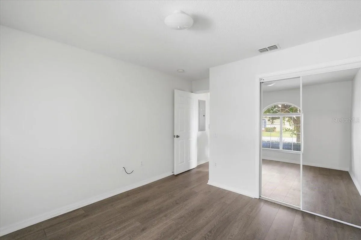 Spacious first bedroom, versatile layout ideal for use as a home office or guest suite.