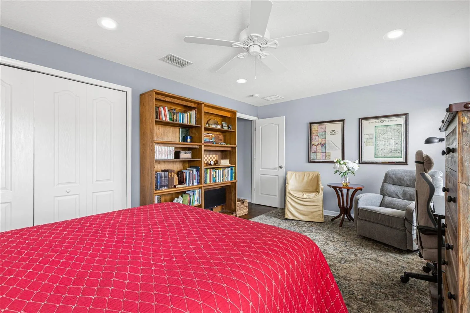 Soft neutral walls, hardwood flooring, a ceiling fan and a built-in closet complete Bedroom 3.