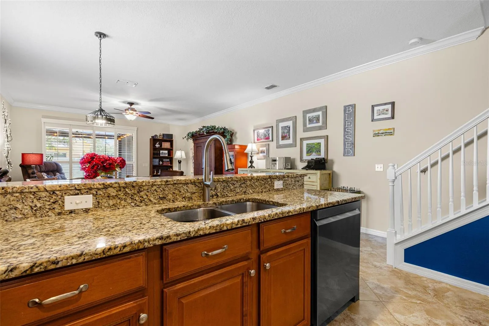 The raised breakfast bar creates a natural spot for casual meals and serving, while the double-basin sink overlooks the living area.