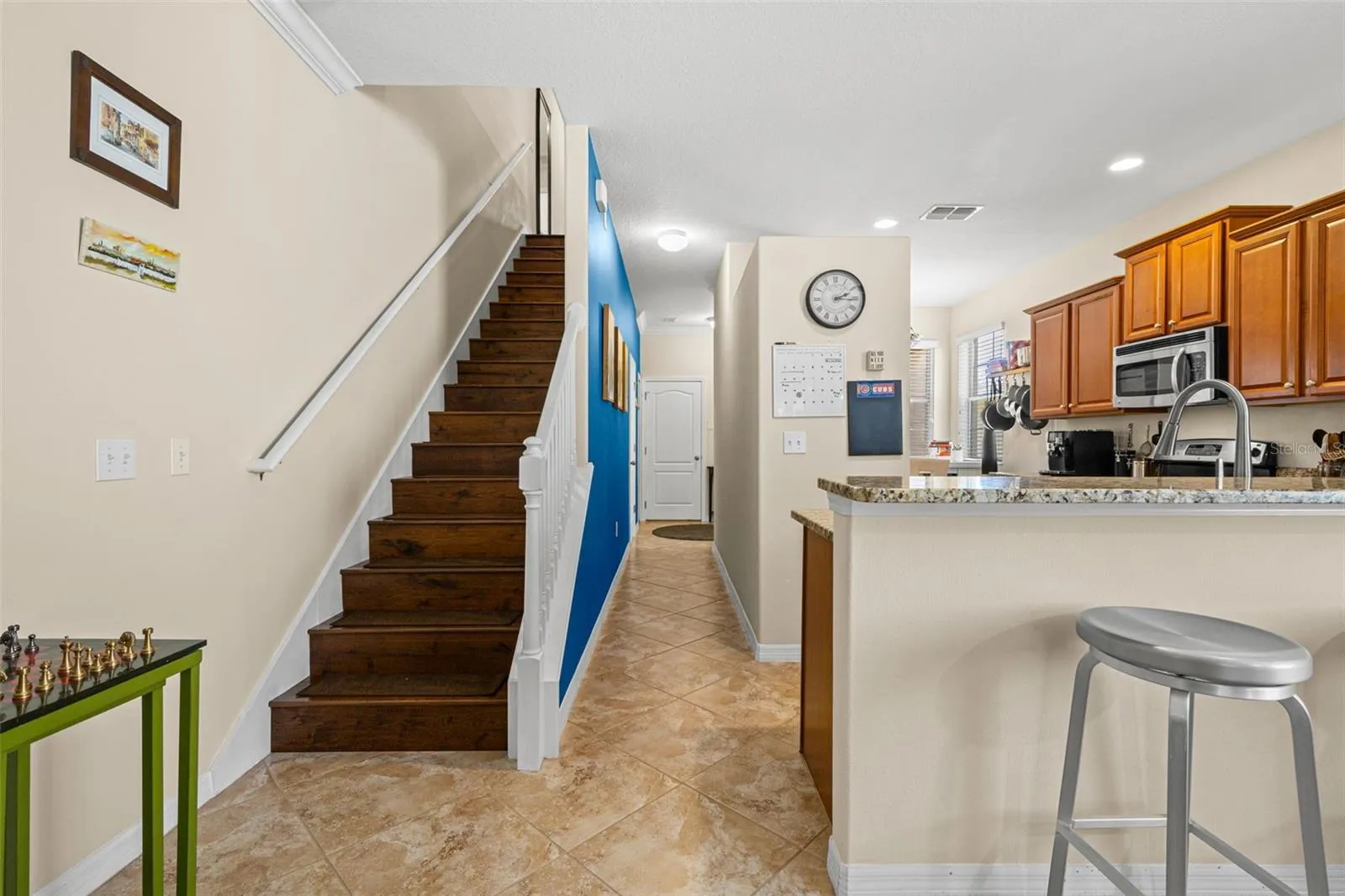 Wood stair treads add warmth to the first floor, while the breakfast bar offers a convenient seat just outside the kitchen.