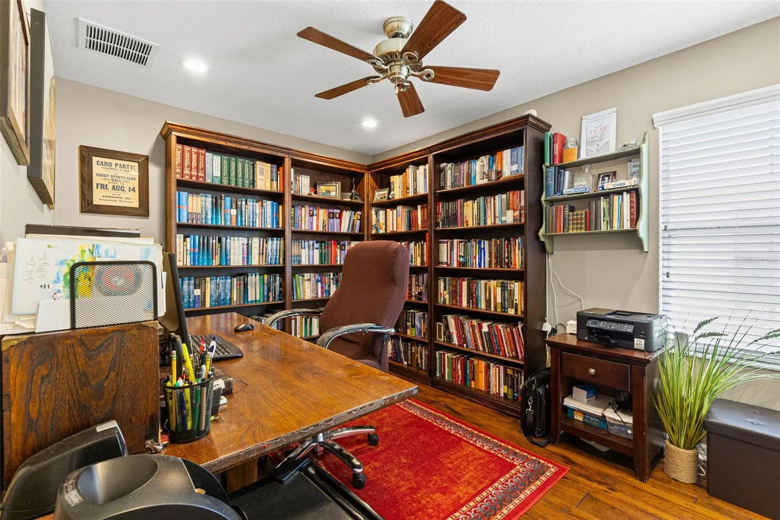 Bedroom 2 is currently used as a home office and library, showing how easily the room can adapt to work, hobbies or guest space. Hardwood flooring, recessed lighting and a ceiling fan complete the room.