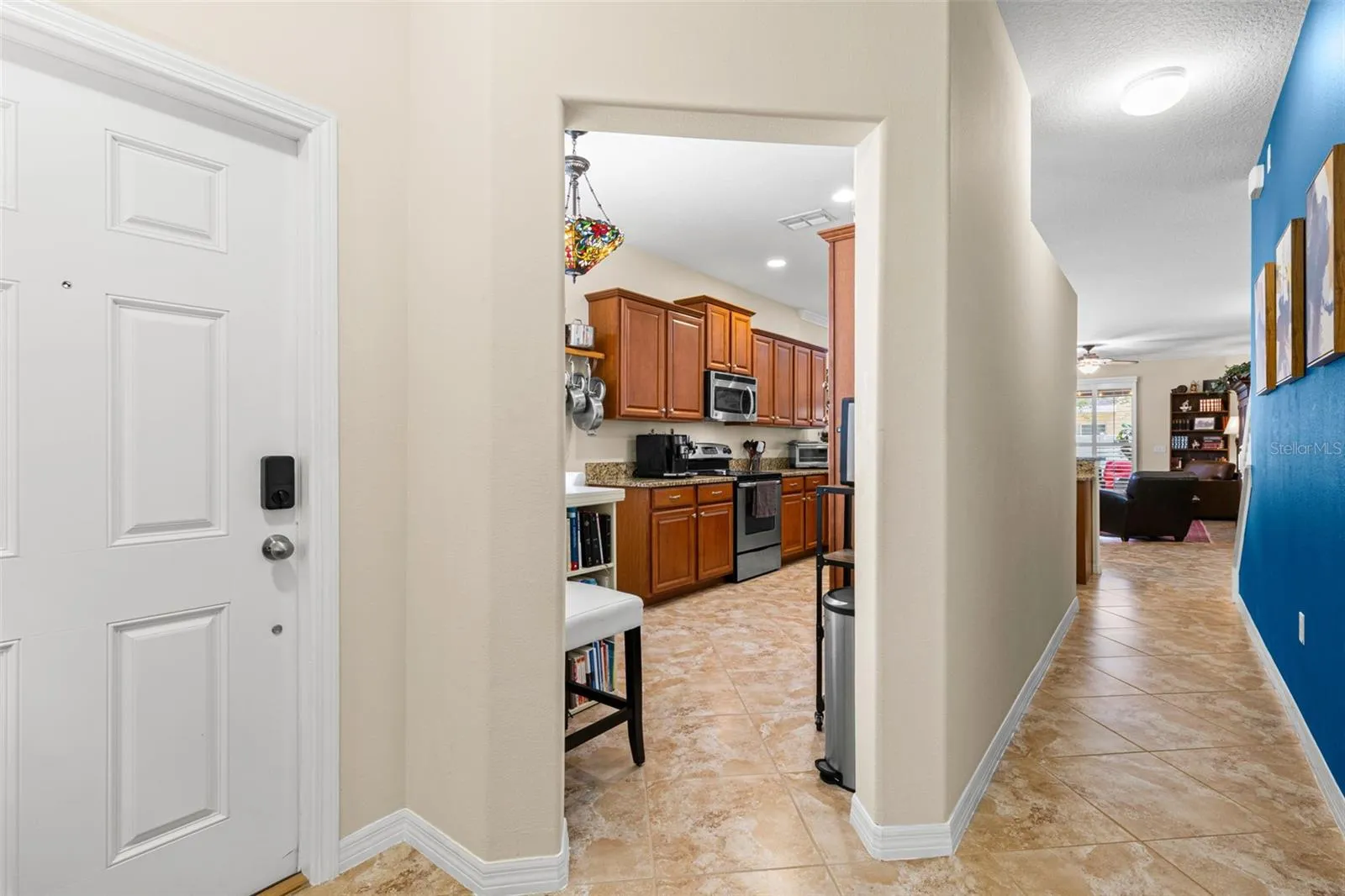 The front entry opens to diagonal tile flooring, a direct view into the kitchen and an easy sightline toward the living area beyond.