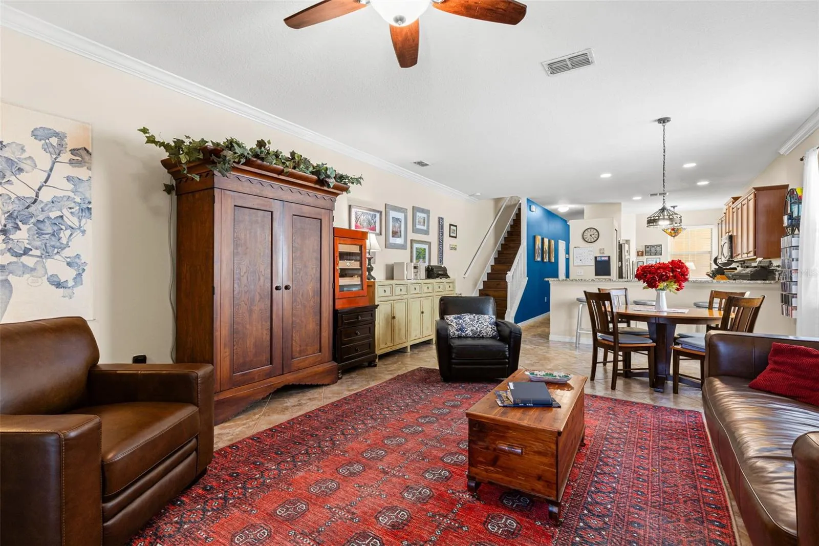Another view of the living room shows its generous scale and easy connection to the dining area and kitchen, with crown molding continuing throughout the first floor.
