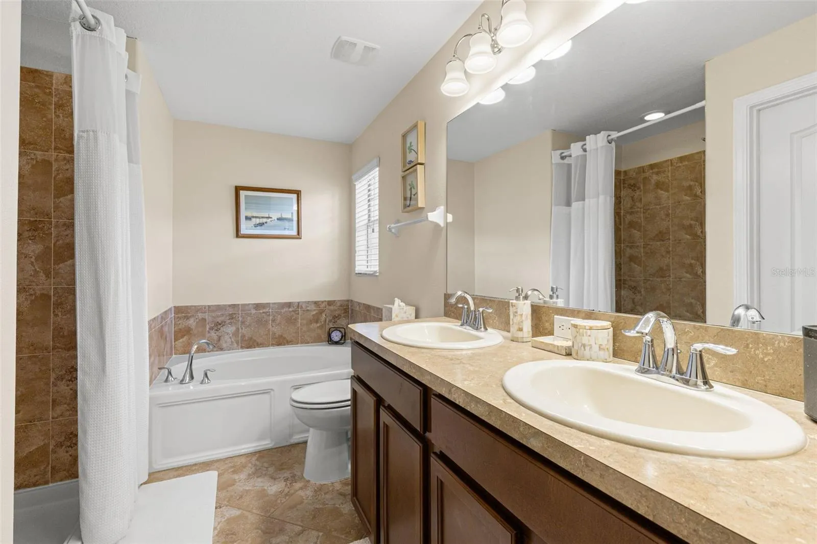 The en suite bath includes a double vanity, soaking tub and separate shower, with a window bringing in natural light.