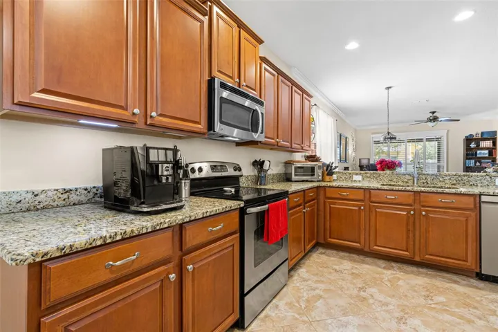 Solid wood cabinetry, granite counters and recessed lighting give the kitchen a warm, polished look with plenty of workspace and storage.