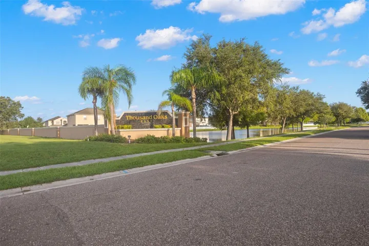 The Thousand Oaks East entrance is framed by palms, mature trees and a neighborhood pond.