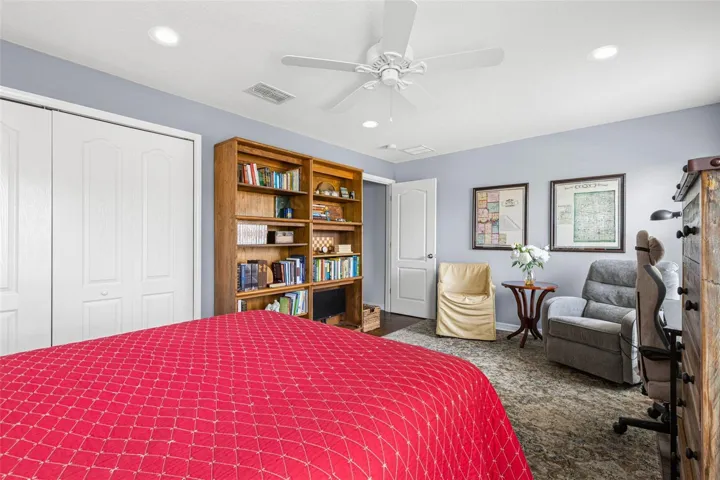 Soft neutral walls, hardwood flooring, a ceiling fan and a built-in closet complete Bedroom 3.