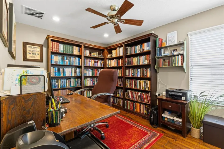Bedroom 2 is currently used as a home office and library, showing how easily the room can adapt to work, hobbies or guest space. Hardwood flooring, recessed lighting and a ceiling fan complete the room.