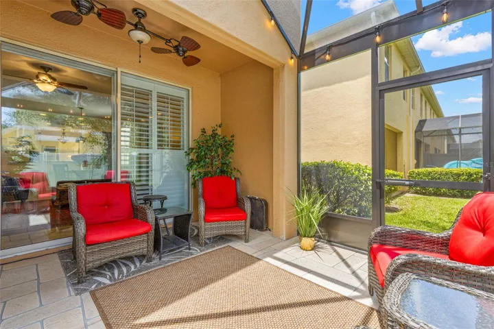 The screened lanai includes a covered seating area with a ceiling fan overhead, creating a comfortable spot to relax outdoors in shade and breeze.