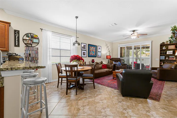 The dining area sits naturally between the kitchen and living room, while plantation shutters across the patio doors provide light control and privacy.