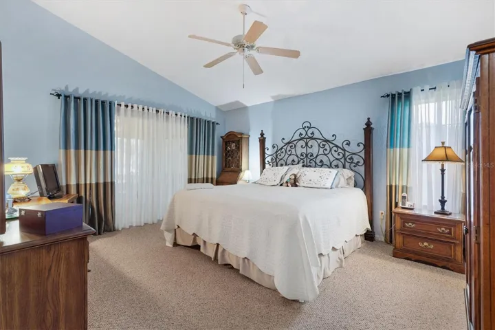 Primary en-suite with vaulted ceiling, sliding doors lead out to Florida room.