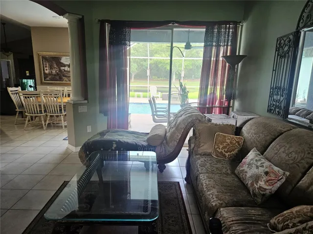 Entry to living room that opens to kitchen and view of pool