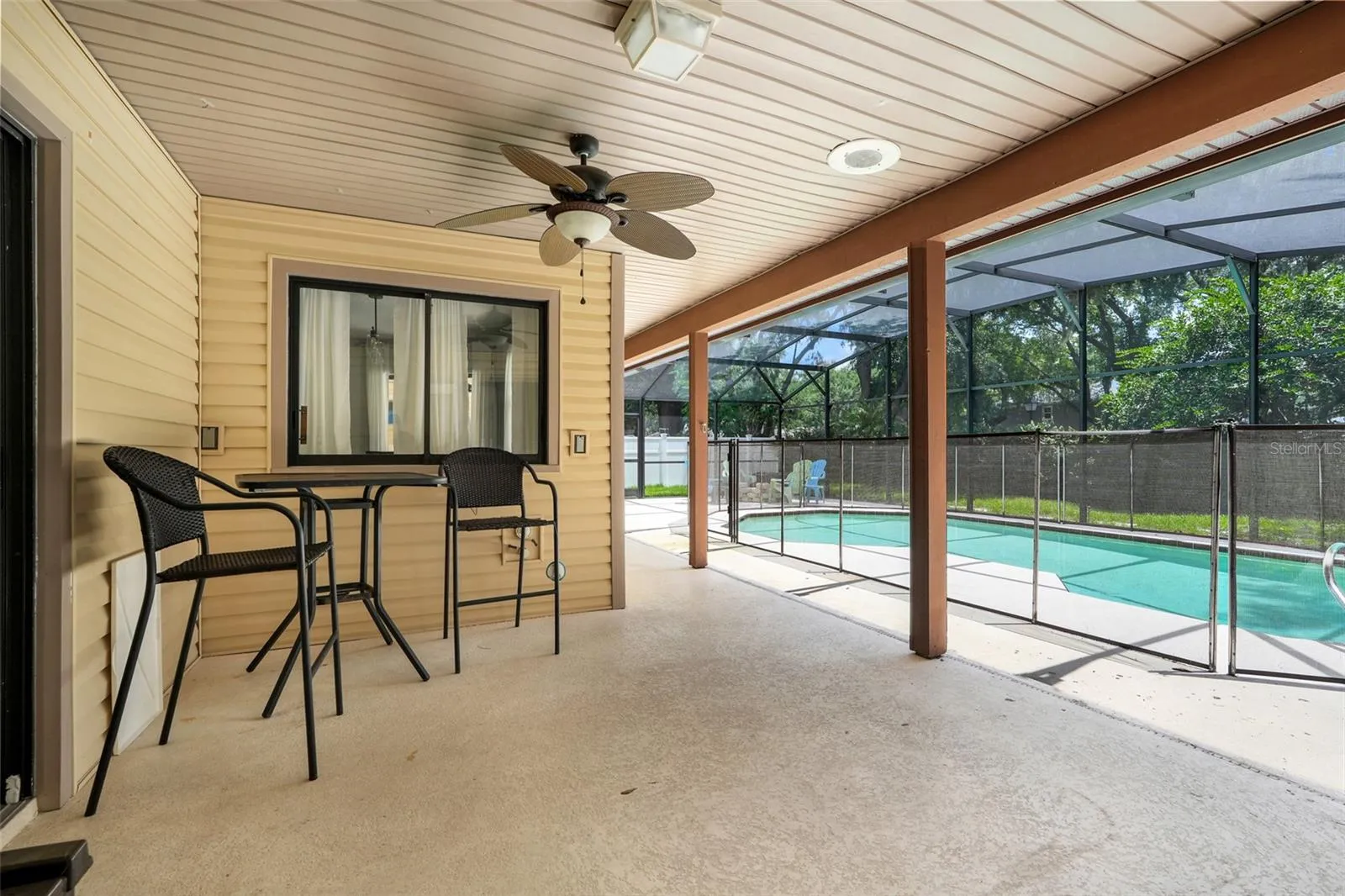Covered patio showcasing the pass through window from dinette area and sliding glass doors from living room.  This area is also plumbed for an outdoor kitchen.