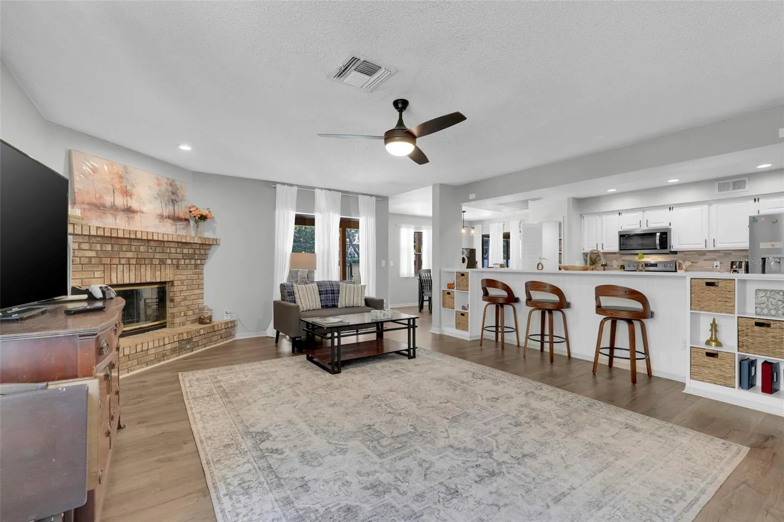 Family room with wood burning fireplace and sliding glass doors leading to pool.